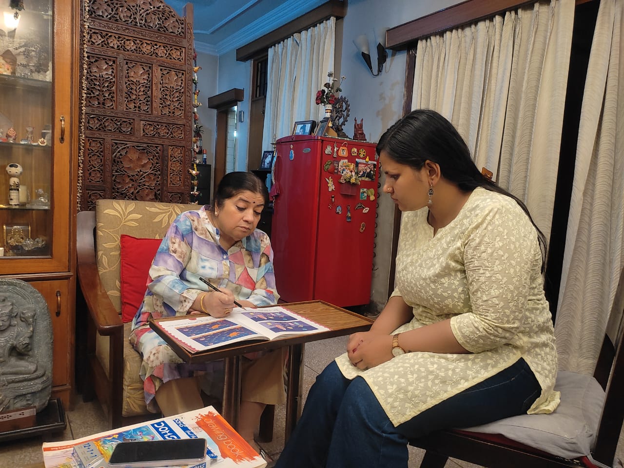 senOcare caregiver helping a dementia patient with a cognitive activity book at home