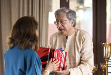 Senior man giving surprise gift to wife