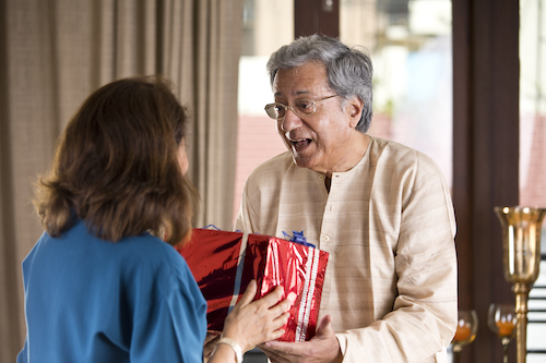 Senior man giving surprise gift to wife