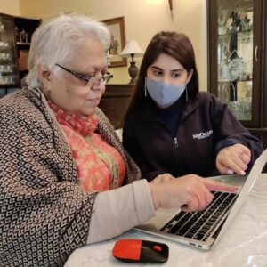 Senocare team helping elderly to use laptop